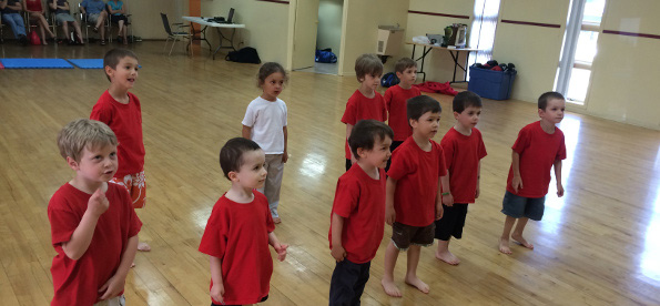 Enfants dans un cours de karaté avec chandails rouges